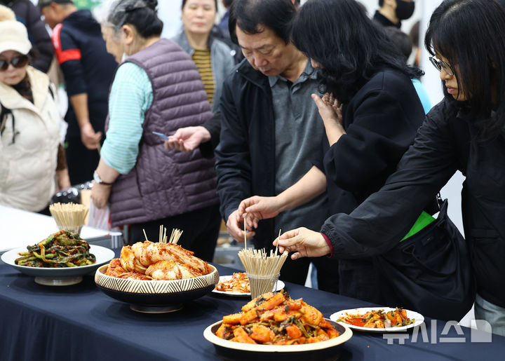 [서울=뉴시스] 박주성 기자 = 김치의 날인 22일 서울 양재동 aT센터에서 열린 2025 대한민국 김장대축제에서 시민들이 김치를 맛보고 있다. 2025.11.22. park7691@newsis.com