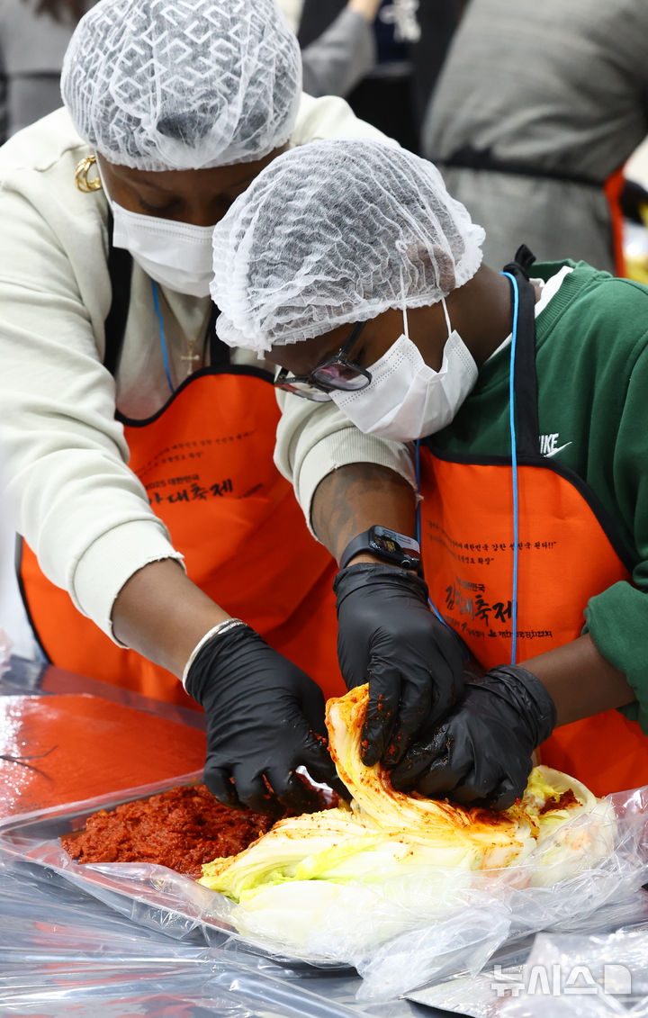[서울=뉴시스] 박주성 기자 = 김치의 날인 22일 서울 양재동 aT센터에서 열린 2025 대한민국 김장대축제 대한민국 김치명인과 함께하는 김치담그기 체험에 참여한 외국인들이 김치를 담그고 있다. 2025.11.22. park7691@newsis.com