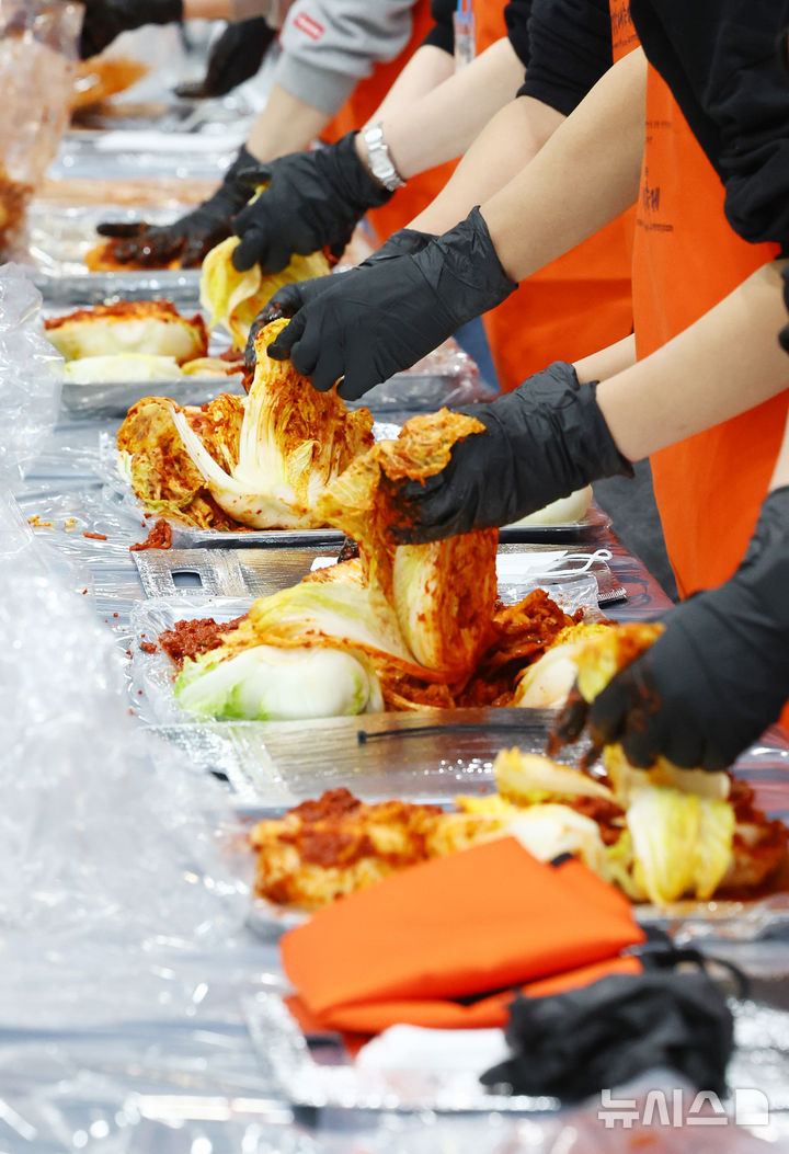 [서울=뉴시스] 박주성 기자 = 김치의 날인 22일 서울 양재동 aT센터에서 열린 2025 대한민국 김장대축제 대한민국 김치명인과 함께하는 김치담그기 체험에서 참가자들이 김치를 담그고 있다. 2025.11.22. park7691@newsis.com