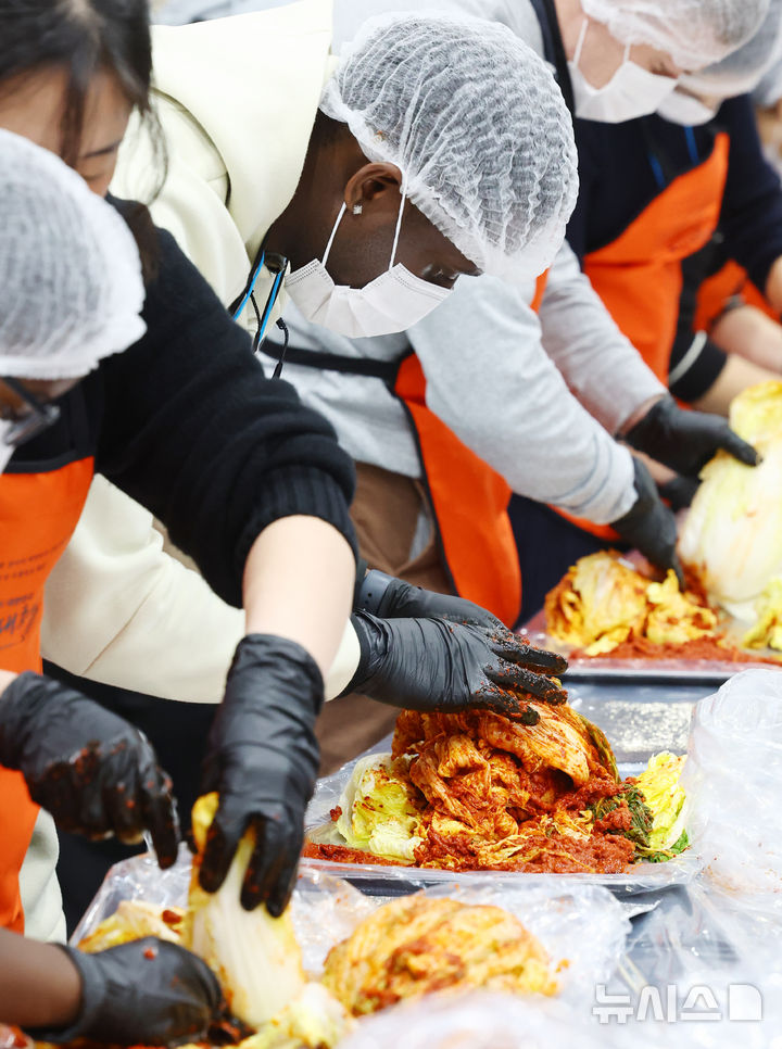 [서울=뉴시스] 박주성 기자 = 김치의 날인 22일 서울 양재동 aT센터에서 열린 2025 대한민국 김장대축제 대한민국 김치명인과 함께하는 김치담그기 체험에 참여한 외국인들이 김치를 담그고 있다. 2025.11.22. park7691@newsis.com