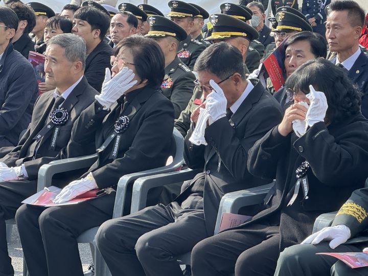 [대전=뉴시스] 김도현 기자 = 23일 오전 대전 유성구 국립대전현충원에서 열린 연평도 포격전 제15주기 전투영웅 추모 및 전승기념 행사에서 고 서정우 하사와 고 문광욱 일병 유가족이 기념 영상을 보며 눈물을 닦고 있다. 2025.11.23. kdh1917@newsis.com *재판매 및 DB 금지