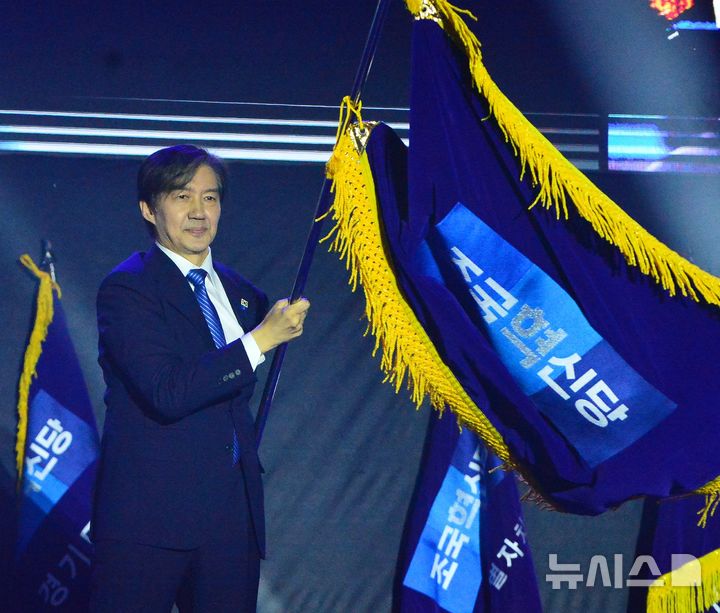 [청주=뉴시스] 서주영 기자 = 23일 충북 청주 오스코에서 열린 조국혁신당 2025전국당원대회에서 조국 신임 당대표가 당기를 이양 받아 흔들고 있다. 2025.11.23. juyeong@newsis.com 