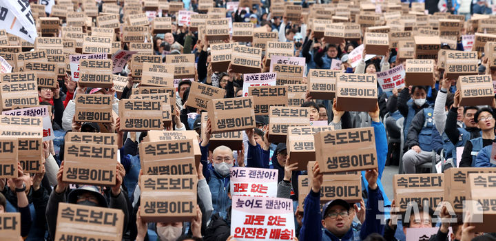 [서울=뉴시스] 추상철 기자 = 23일 오후 서울 종로구 동십자각 앞에서 열린 '과로사 없는 택배 만들기 시민대행진'에서 택배 노조원들이 구호를 외치고 있다. 2025.11.23. scchoo@newsis.com