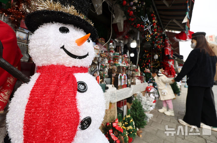 [서울=뉴시스] 홍효식 기자 = 크리스마스를 한 달여 앞둔 23일 서울 중구 남대문시장에서 한 어린이가 엄마 손을 꼭 잡고 크리스마스 장식 용품들을 구경하고 있다. 2025.11.23. yesphoto@newsis.com