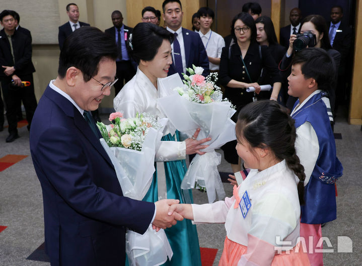 [요하네스버그=뉴시스] 최동준 기자 = 이재명 대통령과 김혜경 여사가 23일(현지 시간) 남아프리카공화국 요하네스버그 한 호텔에서 열린 동포 오찬 간담회에서 화동들에게 꽃다발을 받고 있다. 2025.11.23. photocdj@newsis.com