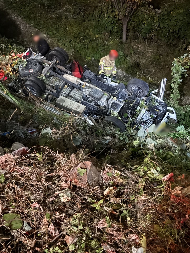 [부산=뉴시스] .23일 오후 10시25분께 부산 기장군의 한 도로에서 A(50대)씨가 몰던 화물차가 신호대기 중인 스포츠유틸리티차량(SUV)을 추돌한 뒤 도로변 7m 추락해 전복됐다. (사진=부산 기장경찰서 제공) 2025.11.23. photo@newsis.com *재판매 및 DB 금지