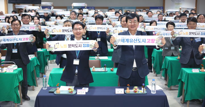 [고창=뉴시스] 지난 21일 장흥군청에서 열린 고창군과 장흥군의 자매결연식, 두 지역의 화합을 상징하 듯 심덕섭 고창군수(앞 왼쪽)는 장흥군의 김성 장흥군수(앞 오른쪽)는 고창군의 도시명 손피켓을 든 채 기념사진을 찍고 있다. *재판매 및 DB 금지