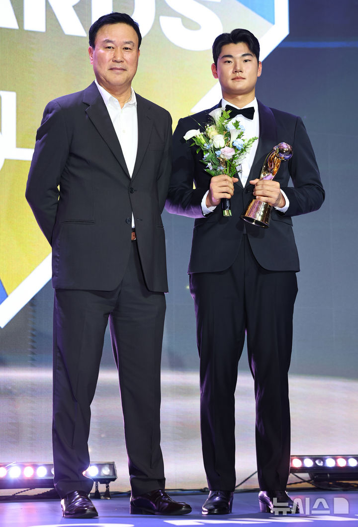 [서울=뉴시스] 최진석 기자 = NC 김주원이 24일 서울 송파구 롯데호텔 월드에서 열린 '2025 KBO 리그 시상식'에서 유격수부문 수비상을 수상 후 장종훈 총재특별 보좌와 기념촬영하고 있다. 2025.11.24. myjs@newsis.com