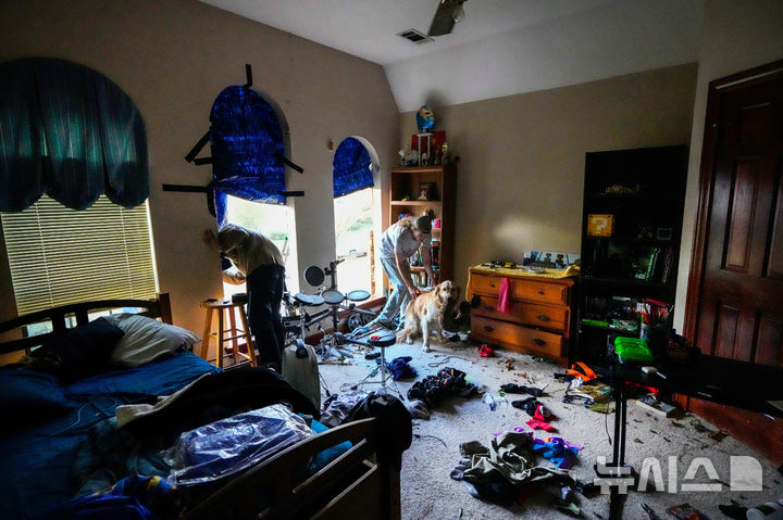 [텍사스주=AP/뉴시스] 24일(현지 시간) 미국 텍사스주 메모리얼 노스웨스트 지역에서 주민들이 토네이도로 인해 파손된 주택 창문에 방수포를 설치하고 있다. 2025.11.25.