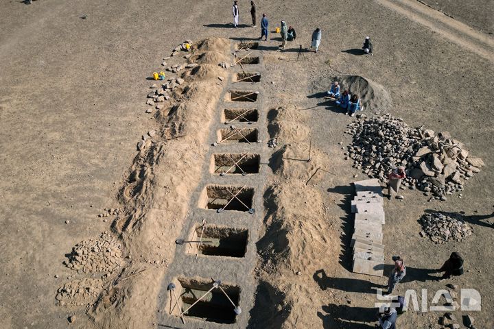 [AP/뉴시스] 야간 폭격으로 사망한 아동 9명과 여성 1명을 묻을 묘가 마련되고 있다