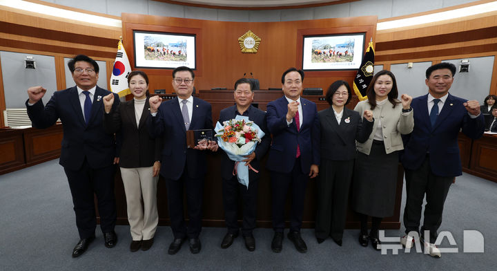 [오산=뉴시스] 오산시의회 의원들과 이권재 시장이 명예의장으로 위촉된 김동필 신장동 주민자치위원장과 기념사진을 찍고 있다. (사진=오산시의회 제공)2025.11.25.photo@newsis.com 