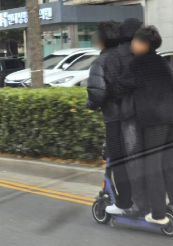 [서울=뉴시스]온라인 커뮤니티에 전동킥보드 위 중학생으로 보이는 세 명이 동시에 올라 차도 가장자리를 주행하고 있는 사진 세 장이 게시됐다.2025.11.25.(사진=보배드림 캡처) *재판매 및 DB 금지