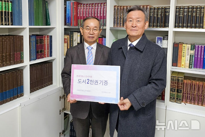 [군포=뉴시스] 민장기 목사(사진 왼쪽)가 신현기 도서관장에게 도서 2000여권을 전달하고 있다. (사진=한세대 제공).