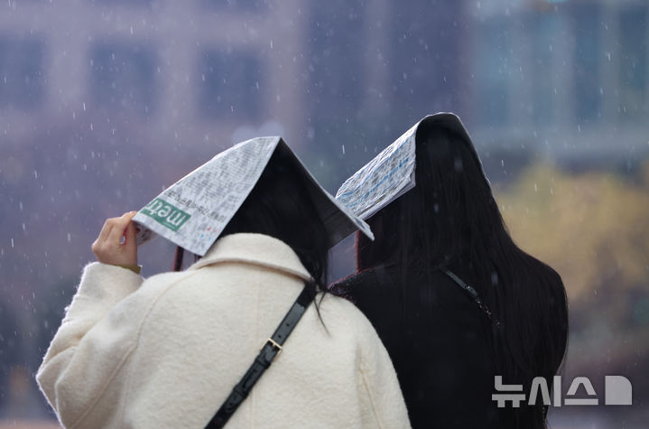 [서울=뉴시스] 황준선 기자 = 황사비가 내린 25일 오전 서울 중구 세종대로에서 시민들이 신문지로 비를 피하고 있다. 2025.11.25. hwang@newsis.com