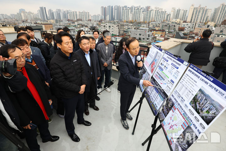 [서울=뉴시스] 황준선 기자 = 오세훈 서울시장이 25일 서울 중랑구 중화동 모아타운 방문해 개발 계획 등 설명을 듣고 있다. 서울시는 오는 2030년까지 중화동 모아타운에 최고 35층짜리 공동 주택을 지어 총 2801호를 공급할 계획이다. 2025.11.25. hwang@newsis.com