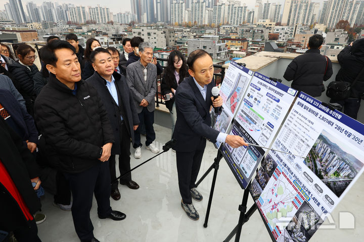 [서울=뉴시스] 황준선 기자 = 오세훈 서울시장이 25일 서울 중랑구 중화동 모아타운 방문해 개발 계획 등 설명을 듣고 있다. 서울시는 오는 2030년까지 중화동 모아타운에 최고 35층짜리 공동 주택을 지어 총 2801호를 공급할 계획이다. 2025.11.25. hwang@newsis.com