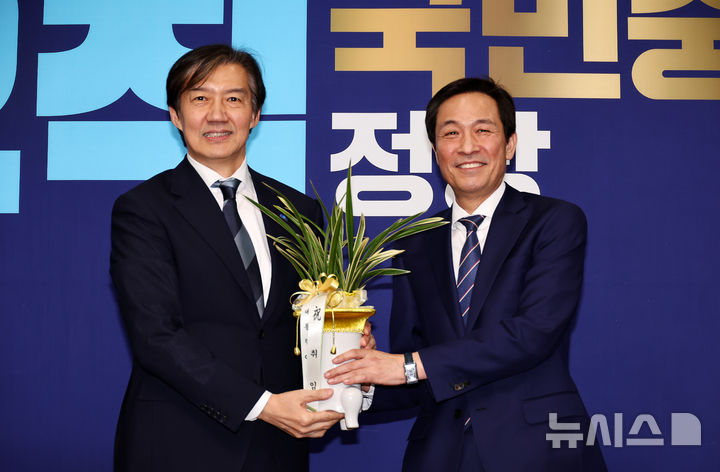 [서울=뉴시스] 김명년 기자 = 조국 조국혁신당 대표가 25일 오후 서울 여의도 국회에서 우상호 대통령실 정무수석에게 이재명 대통령이 보낸 취임 축하난을 전달받은 뒤 기념촬영하고 있다. 2025.11.25. kmn@newsis.com