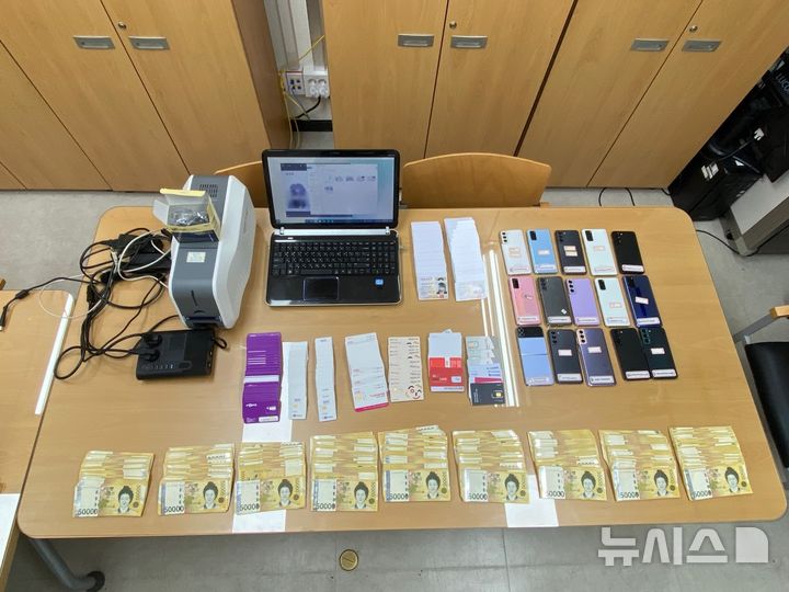 [서울=뉴시스] 경찰이 스미싱 조직 국내 총책 일당을 검거하면서 압수한 휴대전화 공기계와 위조 신분증 등. (사진=서울경찰청 사이버수사과 제공) 2025.11.26. photo@newsis.com