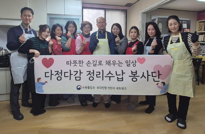 [수원=뉴시스] 봉사활동을 진행한 뒤 기념촬영을 하고 있는 수원출입국·외국인청 직원과 이민자네트워크 봉사단원의 모습. (사진=수원출입국외국인청 제공) 2025.11.26 photo@newsis.com *재판매 및 DB 금지