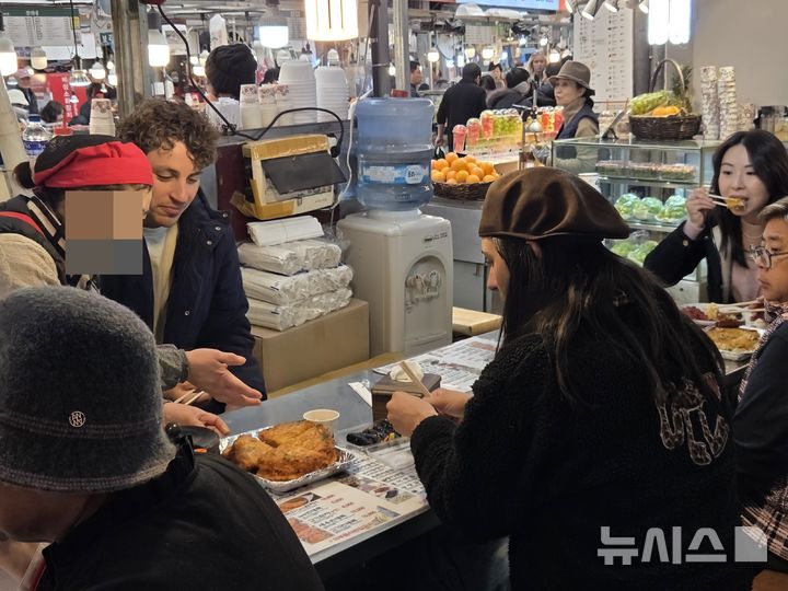 [서울=뉴시스]김윤영 수습기자=26일 오후 12시께 찾은 서울 종로구 광장시장 내 노점에 외국인 관광객들이 방문해 음식을 먹고 있다. 2025.11.26 photo@newsis.com