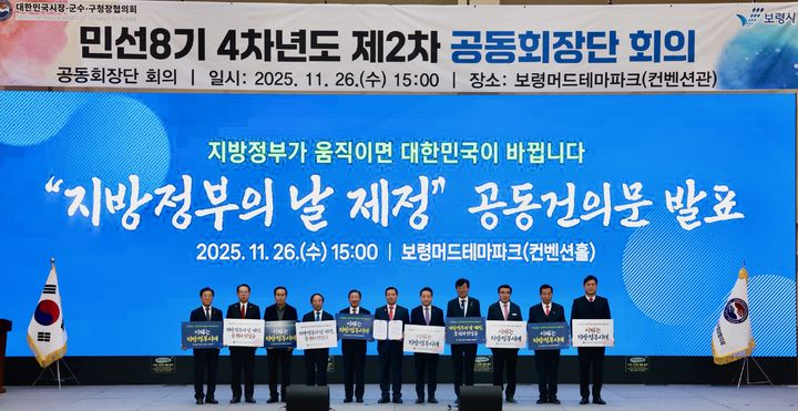 [보령=뉴시스] 충남 보령시 보령머드테마파크에서 26일 열린 대한민국시장군수구청장협의회 제2차 정기회의에서 공동회장단이 '지방정부의 날 제정'을 촉구하는 공동 건의문을 들고 기념 사진을 찍고 있다. (사진=보령시 제공) 2025.11.26. photo@newsis.com *재판매 및 DB 금지