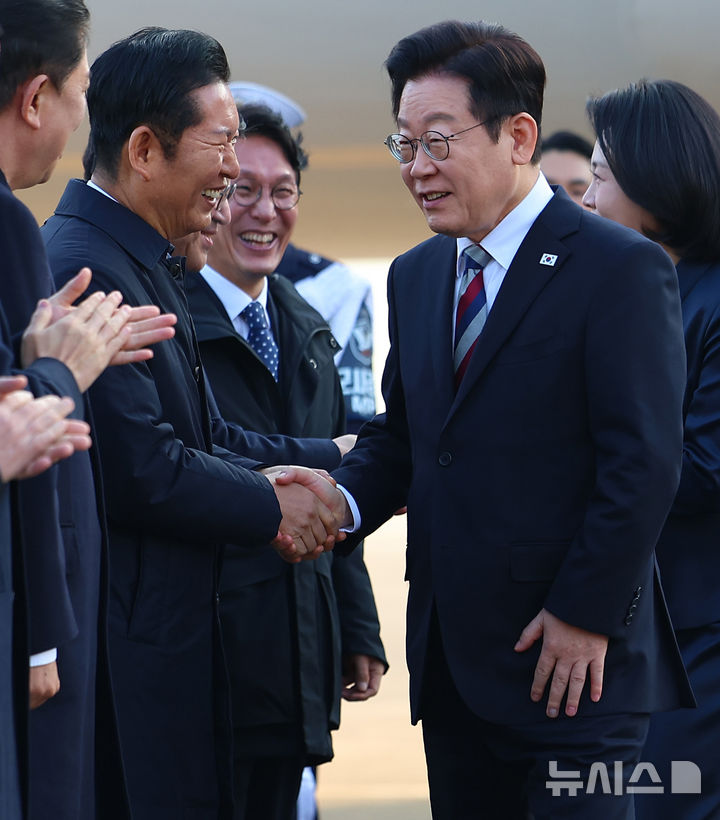 [성남=뉴시스] 최동준 기자 = G20 정상회의 등 중동·아프리카 순방 일정을 마친 이재명 대통령이 26일 경기 성남공항에 도착해 정청래 더불어민주당 대표와 악수하고 있다. 2025.11.26. photocdj@newsis.com