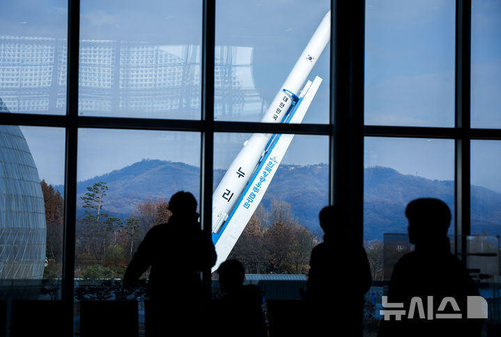 [과천=뉴시스] 정병혁 기자 = 누리호 4차 발사를 하루 앞둔 26일 경기 과천시 국립과천과학관을 찾은 관람객들이 누리호 모형 기립 모습을 바라보고 있다. 민간 기업인 한화에어로스페이스가 기술 이전을 통해 발사체 제작 전 과정을 주관한 누리호는 오로라·대기광 관측과 우주 자기장·플라스마 측정을 위한 위성 13기가 탑재됐으며 27일 새벽 1시쯤 발사될 예정이다.2025.11.26. jhope@newsis.com