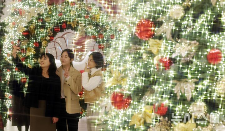  [부산=뉴시스] 하경민 기자 = 26일 부산 해운대구 신세계센텀시티 지하2층 중앙광장을 찾은 시민들이 화려하게 불을 밝힌 트리를 배경으로 기념사진을 찍고 있다. 신세계 센텀시티는 중앙광장에 높이 4.5m를 포함한 20여 개의 트리를 설치하는 등 오는 12월31일까지 백화점 곳곳에서 크리스마스 및 연말 분위기를 연출한다. 2025.11.26. yulnetphoto@newsis.com