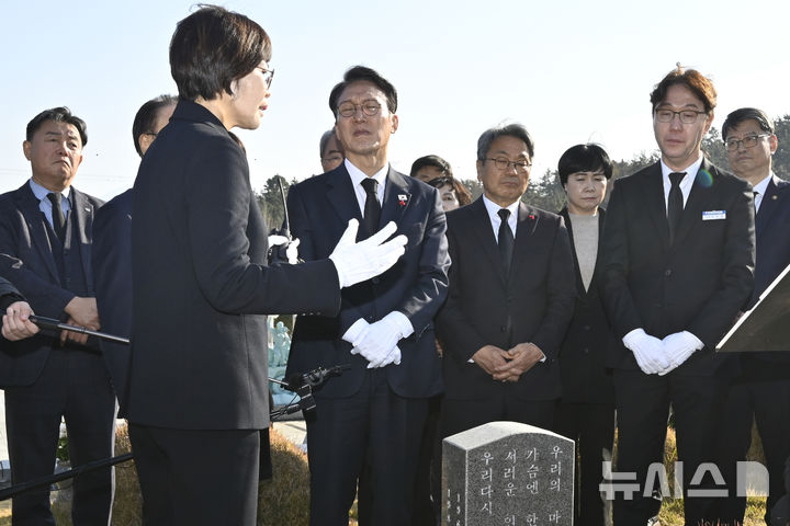 [광주=뉴시스] 박기웅 기자 = 김민석 국무총리가 26일 오후 광주 북구 운정동 국립5·18민주묘지를 방문해 문재학 열사 묘 앞에서 참배한 뒤 해설사의 설명을 듣고 있다. 이날 참배를 마친 김 총리는 기아 오토랜드 광주공장을 시찰, 동천동 골목상권과 1913송정역시장 등을 방문한다. 2025.11.26. pboxer@newsis.com