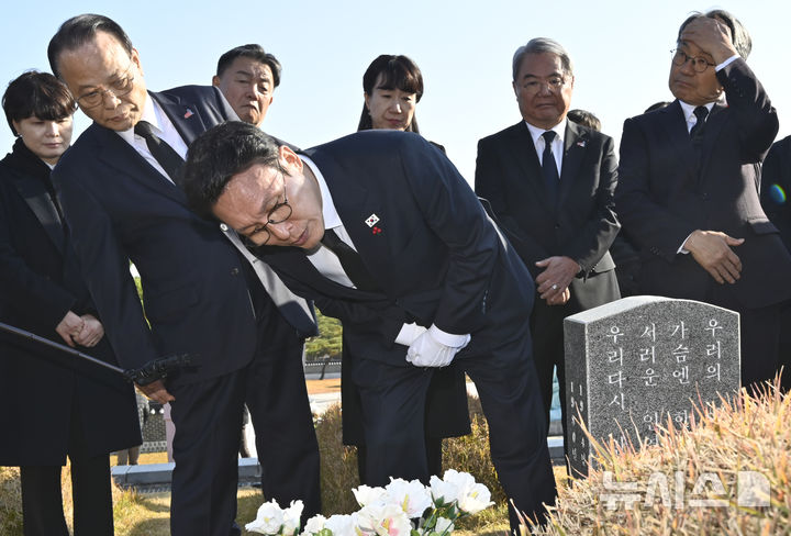 [광주=뉴시스] 박기웅 기자 = 김민석 국무총리가 26일 오후 광주 북구 운정동 국립5·18민주묘지를 방문해 문재학 열사 묘 앞에서 참배한 뒤 묘비를 살펴보고 있다. 이날 참배를 마친 김 총리는 기아 오토랜드 광주공장을 시찰, 동천동 골목상권과 1913송정역시장 등을 방문한다. 2025.11.26. pboxer@newsis.com