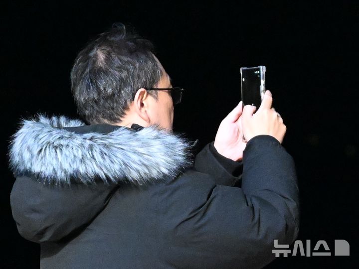 [고흥=뉴시스] 이현행 기자 = 26일 오후 전남 고흥군 우주발사전망대에서 한 시민이 나로우주센터 제2발사대를 스마트폰 카메라에 담고 있다. 2025.11.26. lhh@newsis.com