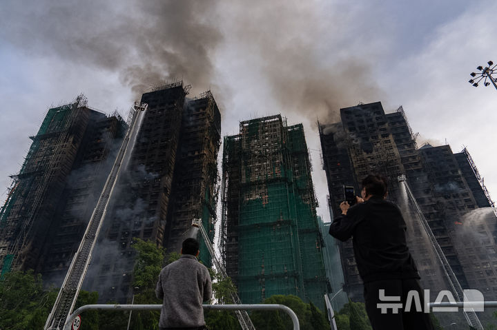 [홍콩=AP/뉴시스] 홍콩 신계의 ‘웡 푹 코트(Wang Fuk Court)’ 고층 아파트 단지에서 화재 발생 하루 가량이 지난 27일에도 검은 연기를 내뿜으며 완전 진화되지 않고 있다. 2025.11.27. 