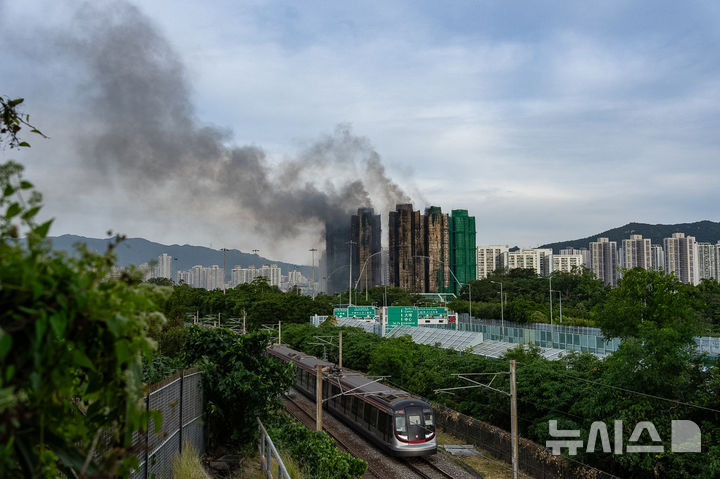 ﻿﻿[홍콩=AP/뉴시스] 26일 화재가 발생한 홍콩 신계 타이포 구역의 고층 아파트 단지에서 이튿날인 27일 오전에도 완전히 진화되지 않아 연기가 오르고 있다. 2025.11.27. 