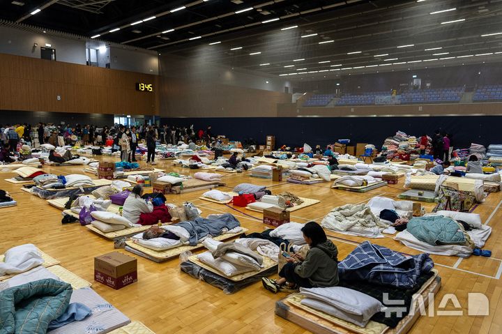 [홍콩=AP/뉴시스] 27일(현지 시간) 홍콩 북부 타이포 구역의 '웡 푹 코트' 아파트 단지 화재 현장 인근에 마련된 임시 대피소에서 이재민들이 휴식하고 있다. 지난 26일 발생한 이 화재로 31층 아파트 8개 동 중 7개 동에 불이 번졌고 최소 94명이 숨지고 70명 이상이 부상을 입었으며 279명이 실종된 것으로 알려졌다. 2025.11.27.