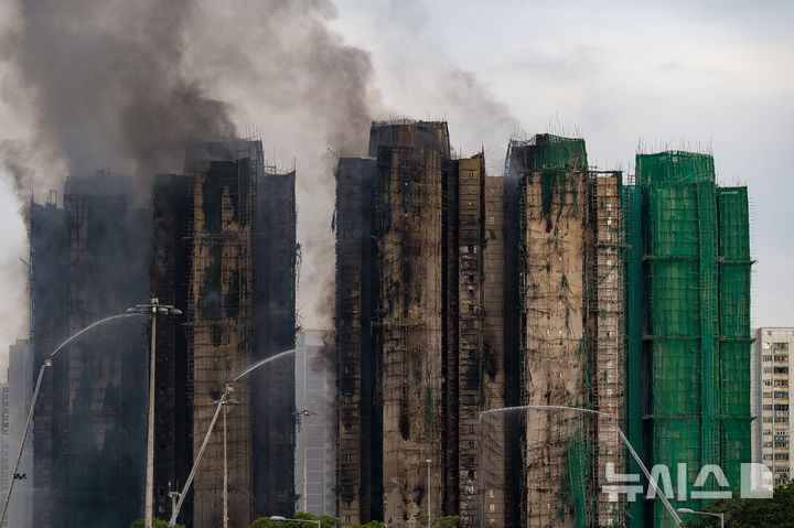 [AP/뉴시스] 홍콩에서 30년래 최대 화재가 난 타이포 지구 왕푹 코트 아파트단지의 화재 발생 27시간 뒤인 27일 오후 6시 모습