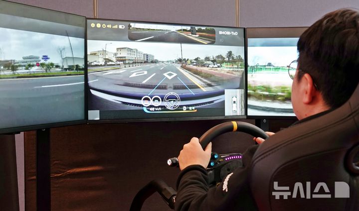 [제주=뉴시스] 오영재 기자 = 27일 오후 제주시 쏘카터미널에서 열린 원격 운전 실증 성과 공유회에서 관계자가 원격 조종을 통해 차량을 실제로 운전하고 있다. 2025.11.27. oyj4343@newsis.com 