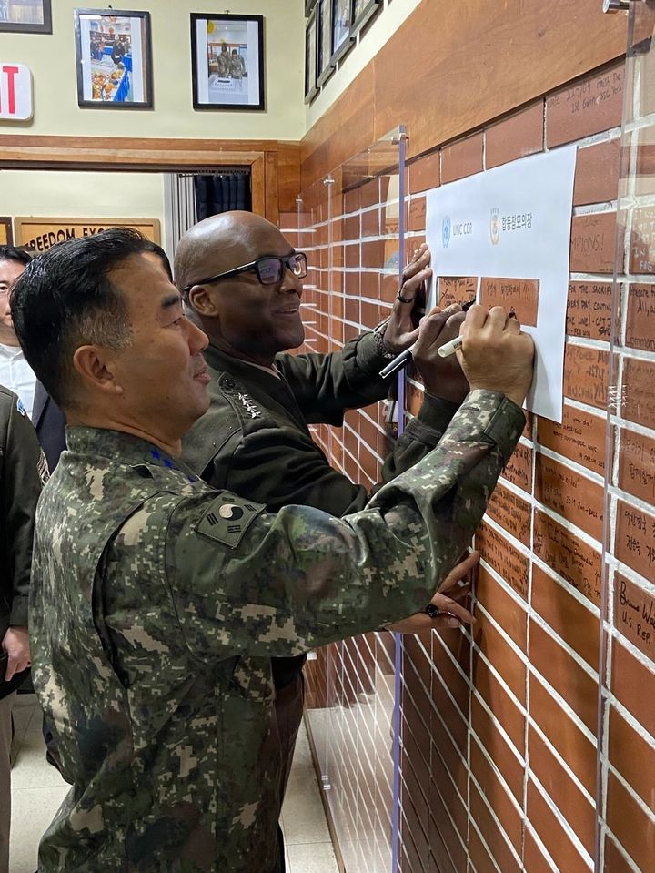 [서울=뉴시스] 진영승 합참의장과 제이비어 브런슨 유엔군사령관이 미국 추수감사절을 맞아 유엔사 경비대대를 방문해 방명록을 남기고 있다. (사진=유엔사 제공) 2025.11.27. photo@newsis.com *재판매 및 DB 금지