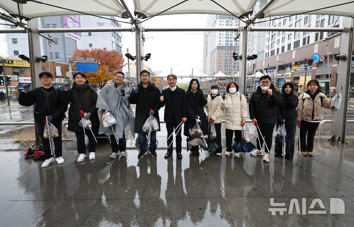 [서울=뉴시스] 최진석 기자 = 염영남(왼쪽 다섯번째) 뉴시스 대표이사와 임직원들로 구성된 자원봉사단이 27일 서울 청계천 일대에서 환경정화 플로깅 봉사활동하며 기념촬영하고 있다. 2025.11.27. myjs@newsis.com