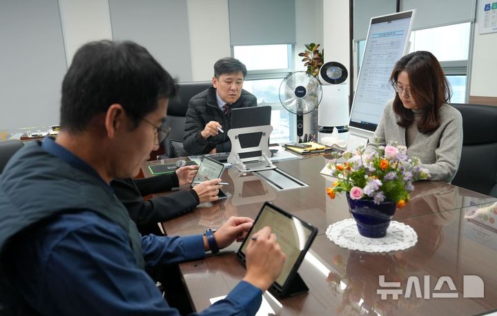 [서울=뉴시스] 한국해양교통안전공단(KOMSA) 김준석 공단 이사장(가운데)이 집무실에서 기획조정실 직원들과 대형 모니터와 태블릿PC를 활용한 '종이 없는 회의'를 진행 중인 모습.