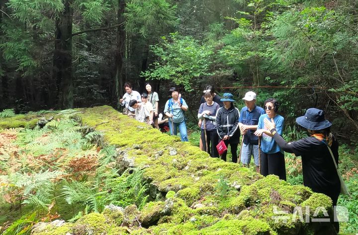 [제주=뉴시스] 양영전 기자 = 서귀포시 호근동 마을 주민인 자연환경해설사가 미로숲을 찾은 탐방객들에게 설명하고 있는 모습. (사진=호근동생태관광협의체 제공)