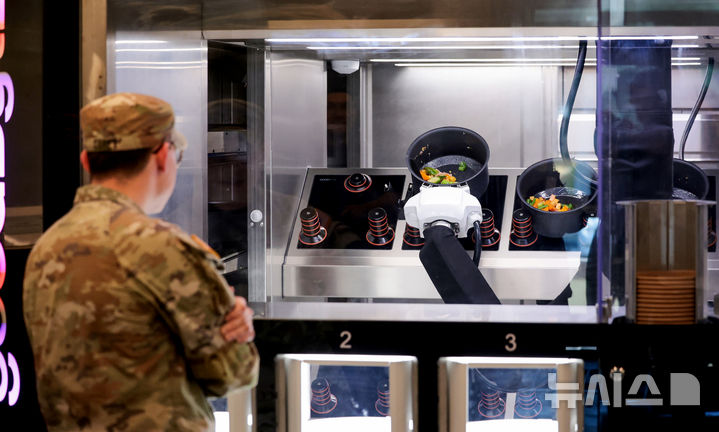 [대구=뉴시스] 이무열 기자 = 28일 대구 남구 주한미군 제19 지원사령부 캠프워커에 설치된 자동화 식당인 ‘마켓 19’에서 한 미군이 로봇이 조리하는 급식을 기다리고 있다. 제19 지원사령부는 자동화 기술이 미군 급식 운영을 어떻게 향상시킬 수 있을지 탐구하기 위해 캠프워커에서 미 육군 최초로 자동화 식당을 이달부터 6개월간 시범 운영한다. 2025.11.28. lmy@newsis.com