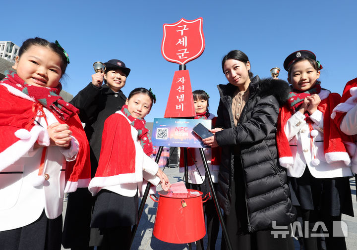 [서울=뉴시스] 추상철 기자 = 28일 오전 서울 종로구 광화문광장에서 열린 '2025 구세군 자선냄비 시종식'에서 서울 주니어 합창단 어린이와 학부모가 현금 및 NFC 자선냄비 모금 시연을 하고 있다. (공동취재) 2025.11.28. photo@newsis.com