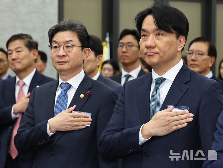 [서울=뉴시스] 최진석 기자 = 이억원(왼쪽) 금융위원장과 이형주 금융정보분석원장이 28일 서울 중구 은행연합회 국제회의실에서 열린 제19회 자금세탁방지의 날 기념식에서 국기에 대한 경례를 하고 있다. 2025.11.28. myjs@newsis.com