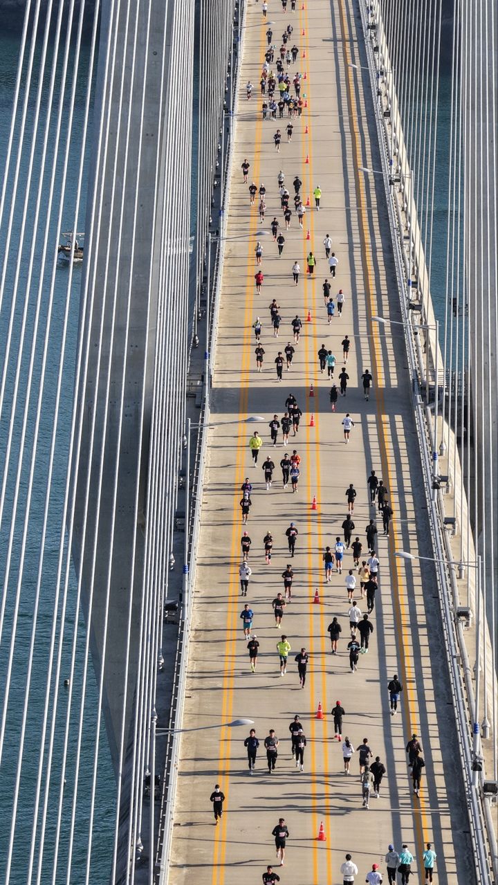 [여수=뉴시스] 김석훈 기자 = 29일 전남 여수와 고흥을 연결하는 해상 교량을 달리는 제1회 '2025 여수일레븐브리지마라톤' 대회 참가 선수들이 화양조발대교를 지나고 있다. 2025.11.29. kim@newsis.com *재판매 및 DB 금지