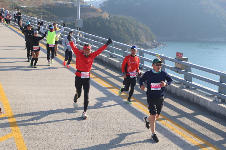 [여수=뉴시스] 김석훈 기자 = 29일 전남 여수와 고흥을 연결하는 해상 교량을 달리는 제1회 '2025 여수일레븐브리지마라톤' 대회 참가 선수들이 둔병대교를 지나며 손을 흔들고 있다. 2025.11.29. kim@newsis.com *재판매 및 DB 금지