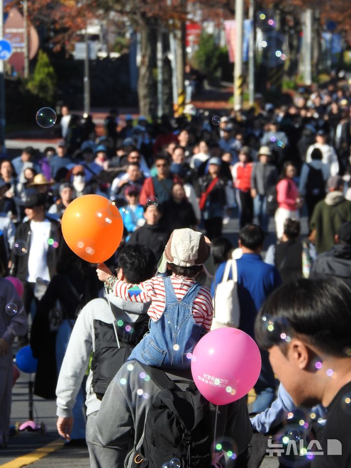 [제주=뉴시스] 김수환 기자 = 30일 오전 화창한 날씨 속 제주 '2025 제2회 차 없는 거리 걷기행사'가 열린 가운데 참가자들이 차량 통행이 제한된 제주시 연삼로를 걷고 있다. 2025.11.30. notedsh@newsis.com