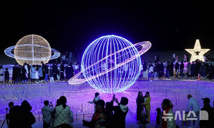  [부산=뉴시스] 하경민 기자 = '제12회 해운대빛축제' 점등식이 열린 29일 부산 해운대구 해운대해수욕장에서 시민과 관광객들이 백사장 180m 구간에 우주를 형상화한 빛 조형물을 구경하고 있다. 해운대구 구남로와 해운대해수욕장 일대에서 열리는 이번 축제는 내년 1월18일까지 계속된다. 2025.11.30. yulnetphoto@newsis.com