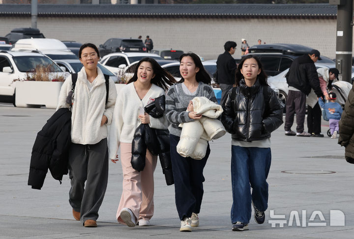[서울=뉴시스] 김명원 기자 = 일요일인 30일 낮 최고기온이 20도까지 오르는 등 포근한 날씨가 이어지는 가운데 서울 종로구 광화문 광장에 나들이 나온 시민들이 한손에 겨울 외투를 벗어 들고 이동하고 있다. 기상청에 따르면, 이날 강원영동을 제외한 중부지방과 제주도는 대체로 흐리겠고 그 밖의 지역에는 가끔 구름이 많은 가운데 기온은 평년 보다 높겠다고 밝혔다. 2025.11.30. kmx1105@newsis.com