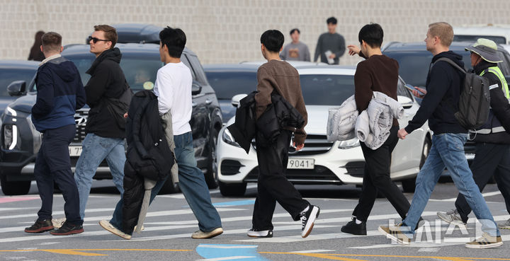 [서울=뉴시스] 김명원 기자 = 일요일인 30일 낮 최고기온이 20도까지 오르는 등 포근한 날씨가 이어지는 가운데 서울 종로구 광화문 광장에 나들이 나온 시민들이 한손에 겨울 외투를 벗어 들고 이동하고 있다. 기상청에 따르면, 이날 강원영동을 제외한 중부지방과 제주도는 대체로 흐리겠고 그 밖의 지역에는 가끔 구름이 많은 가운데 기온은 평년 보다 높겠다고 밝혔다. 2025.11.30. kmx1105@newsis.com
