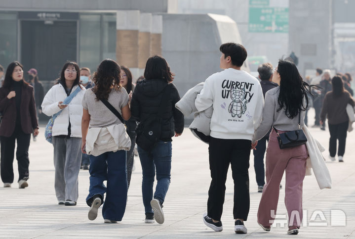 [서울=뉴시스] 김명원 기자 = 일요일인 30일 낮 최고기온이 20도까지 오르는 등 포근한 날씨가 이어지는 가운데 서울 종로구 광화문 광장에 나들이 나온 시민들이 한손에 겨울 외투를 벗어 들고 이동하고 있다. 기상청에 따르면, 이날 강원영동을 제외한 중부지방과 제주도는 대체로 흐리겠고 그 밖의 지역에는 가끔 구름이 많은 가운데 기온은 평년 보다 높겠다고 밝혔다. 2025.11.30. kmx1105@newsis.com